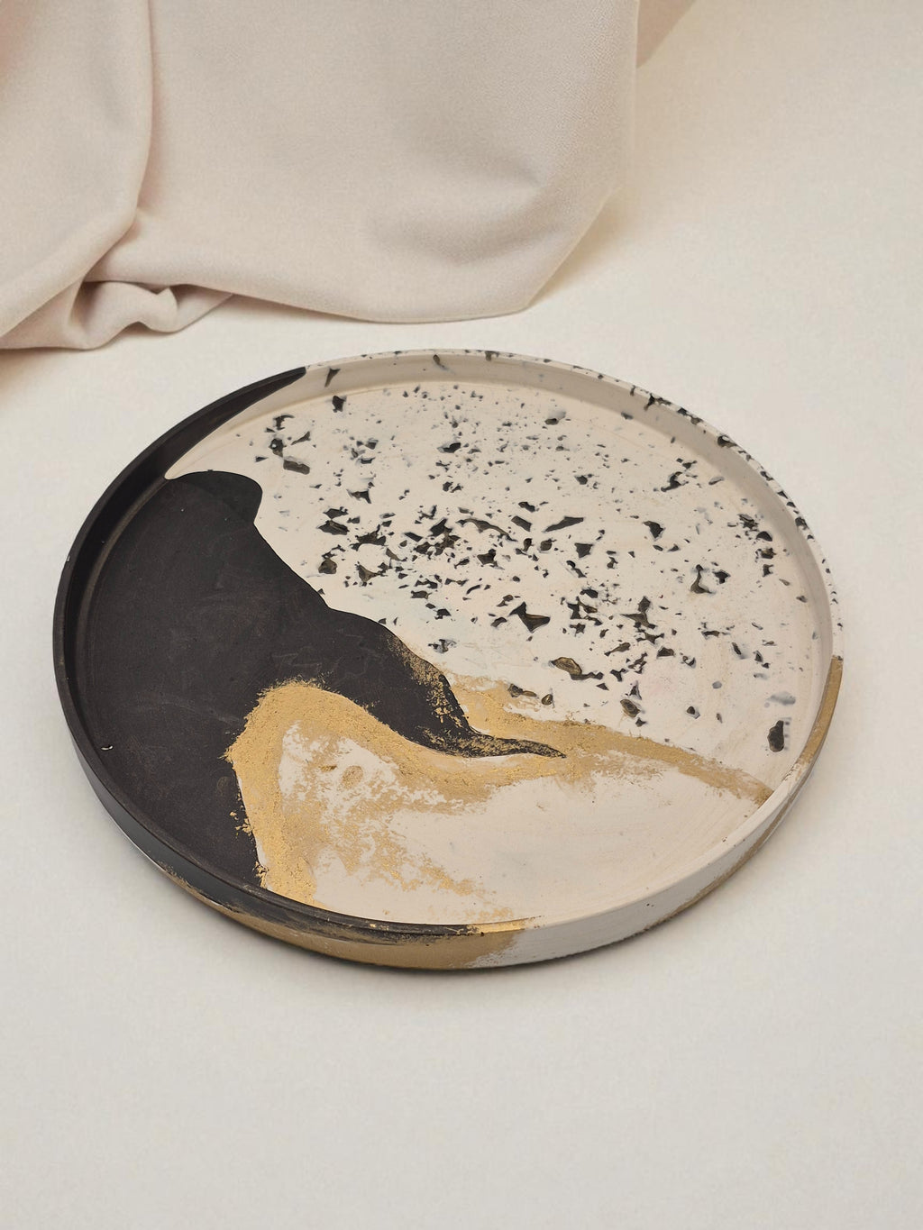 Rundes Jesmonite-Tablett in Schwarz, Weiss und Gold mit Terrazzo-Optik und organischem Farbverlauf – Kollektion Marrakesh – Maliora Designs