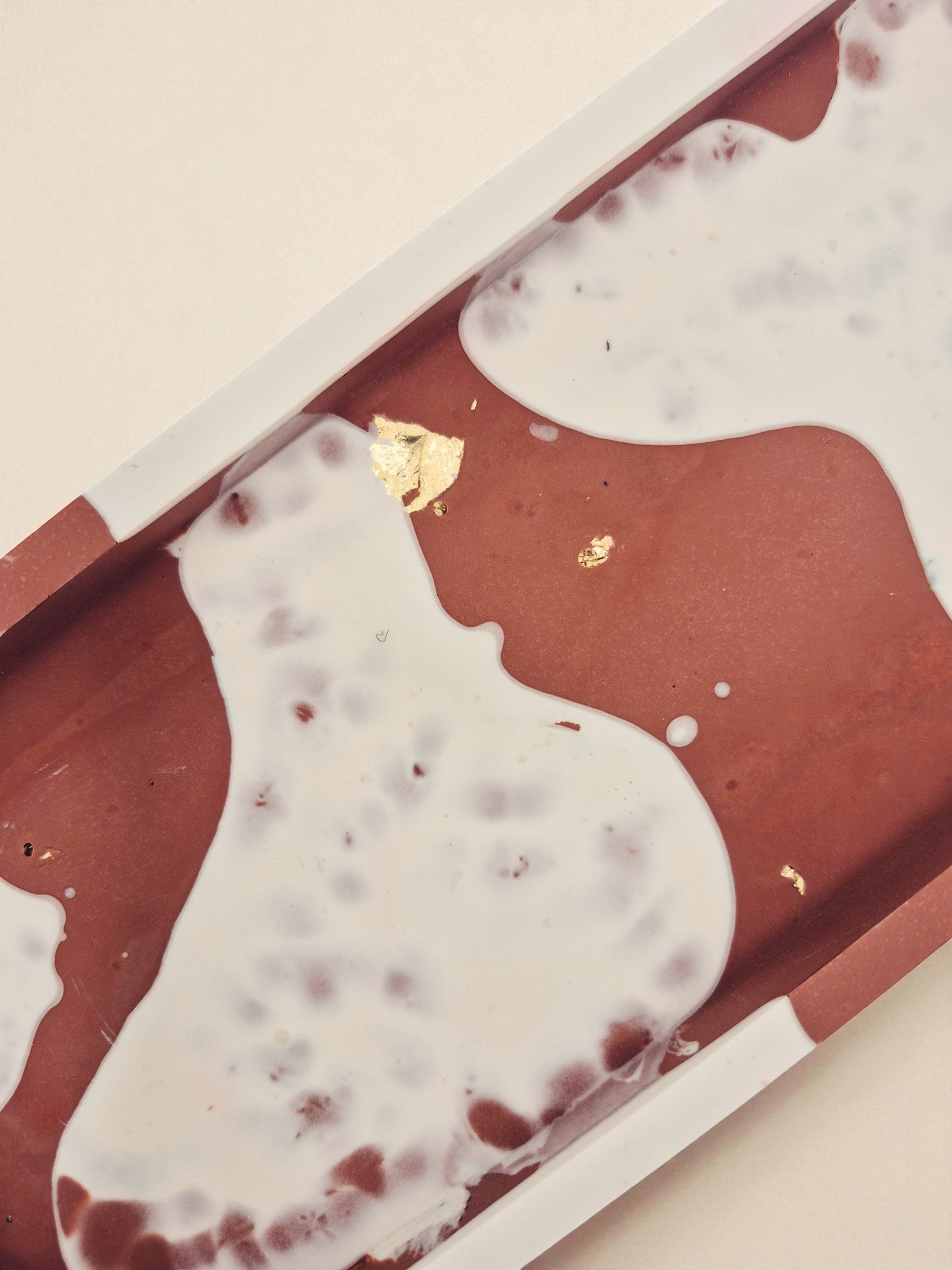 Jesmonite-Tablett in Terrakotta-Weiß, dekorativ platziert auf Holzfläche – Kollektion Sora Terra – Maliora Designs