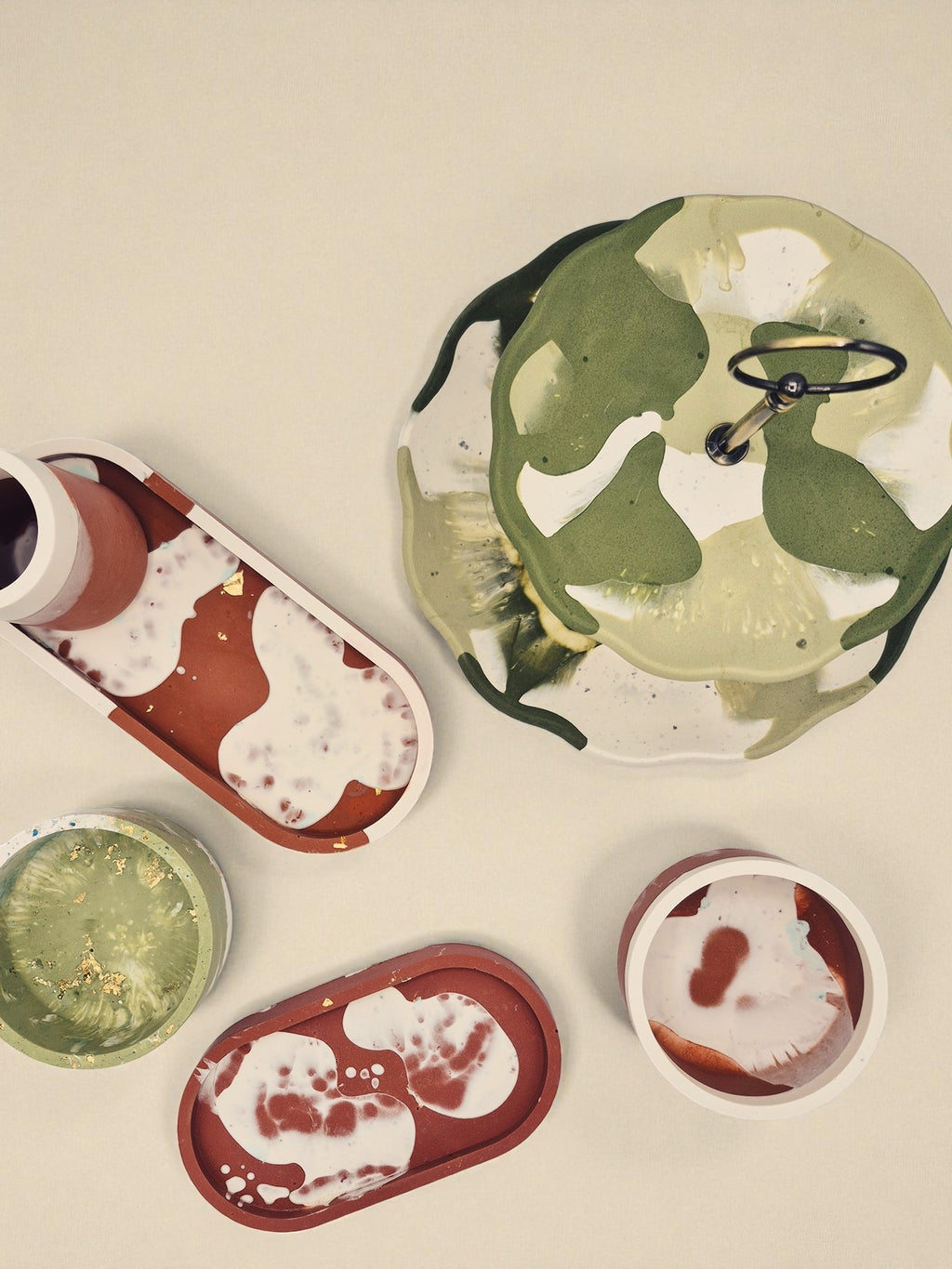 Kombination aus Jesmonite-Tabletts und Tellern in Terrakotta und Olivgrün – Kollektion Sora Terra – Maliora Designs