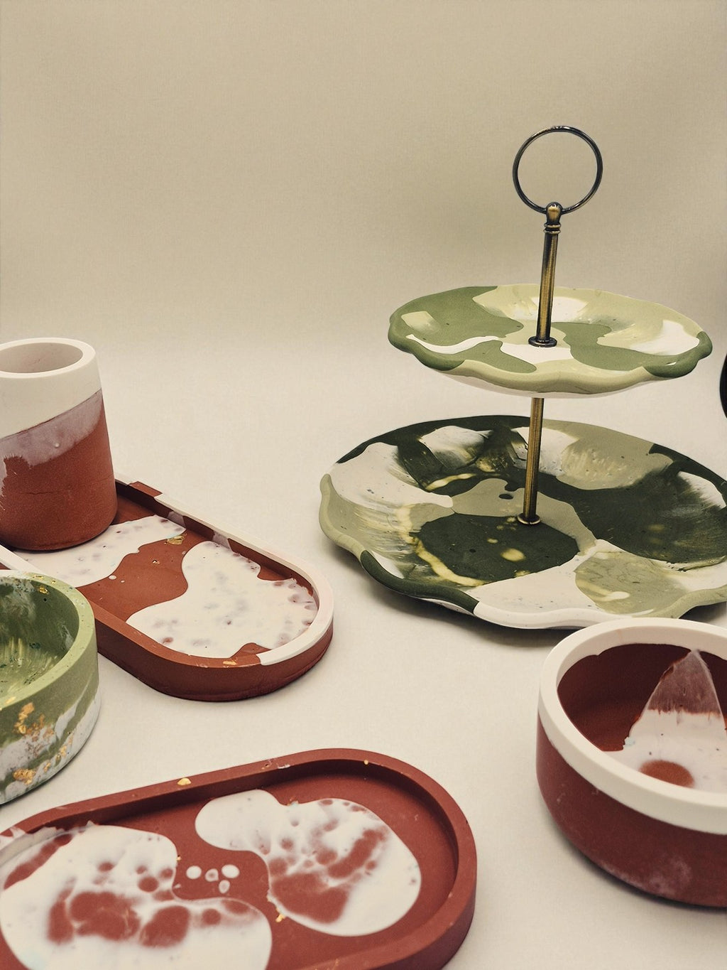 Kombination aus Jesmonite-Tabletts, Tellern und Etageren in Naturtönen – Kollektion Sora Terra – Maliora Designs