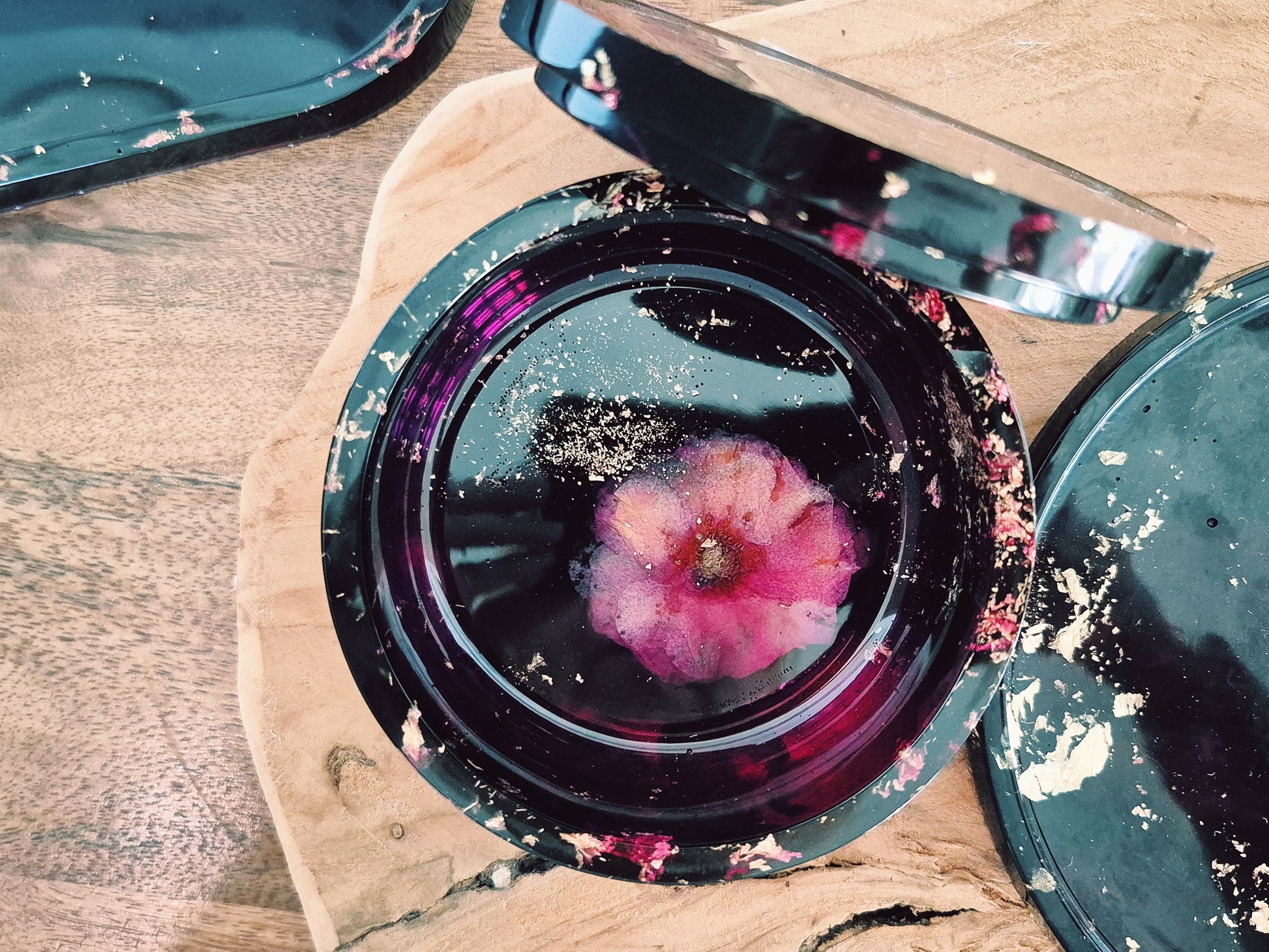 Set aus Epoxidharz-Schalen mit violett-goldenem Farbspiel, arrangiert auf Holzbrett – Maliora Designs