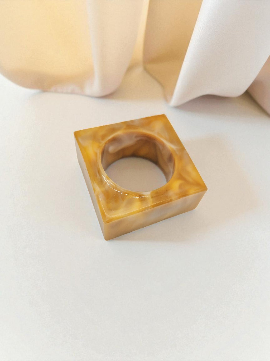 Quadratischer Epoxidharz-Serviettenring in Goldgelb mit sanfter Marmorierung, Kollektion Golden Dawn – Maliora Designs