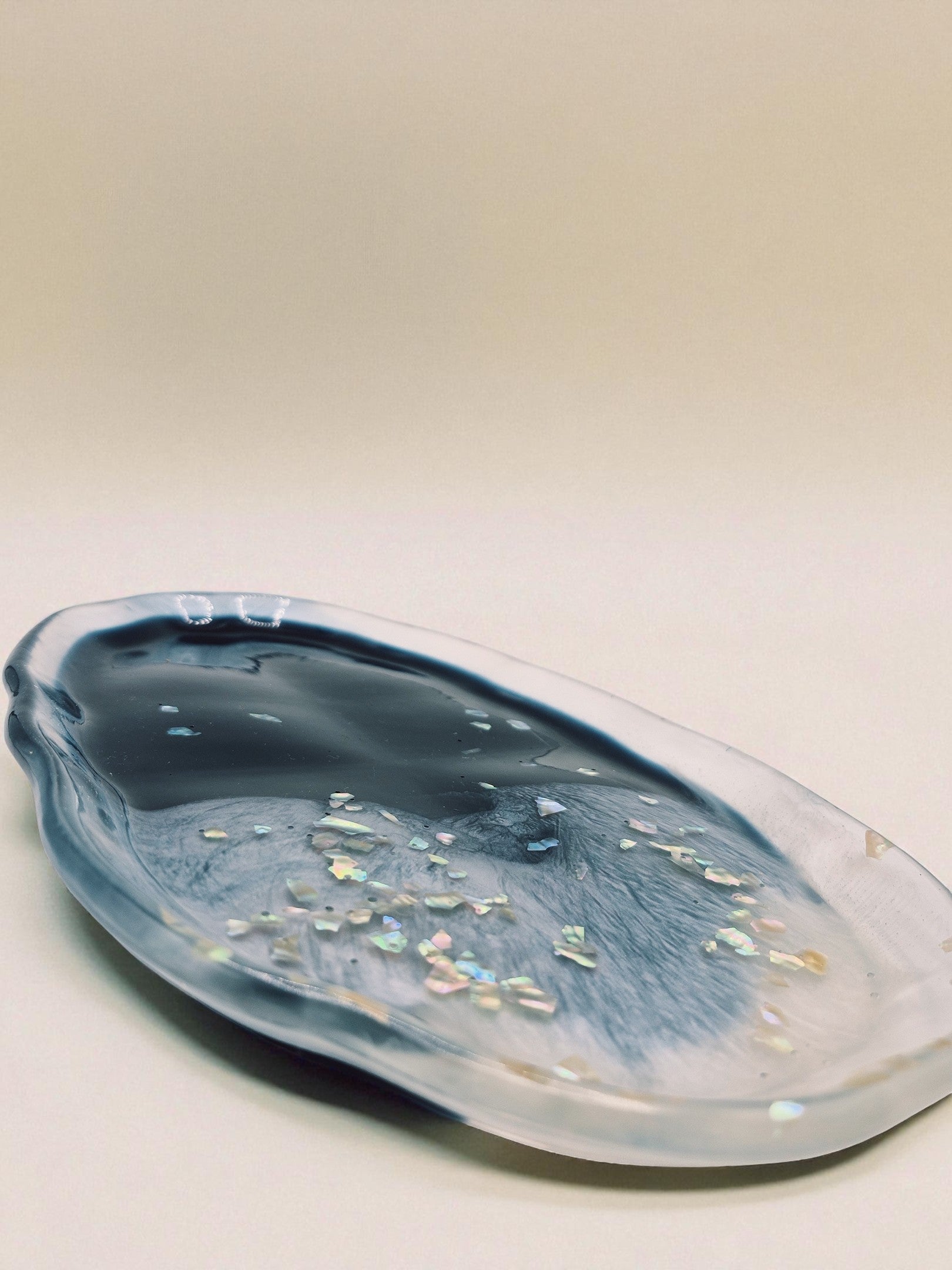 Organischer Epoxidharz-Teller in Blau-Weiß mit glänzender Oberfläche, dekorativ auf Holz platziert – Maliora Designs