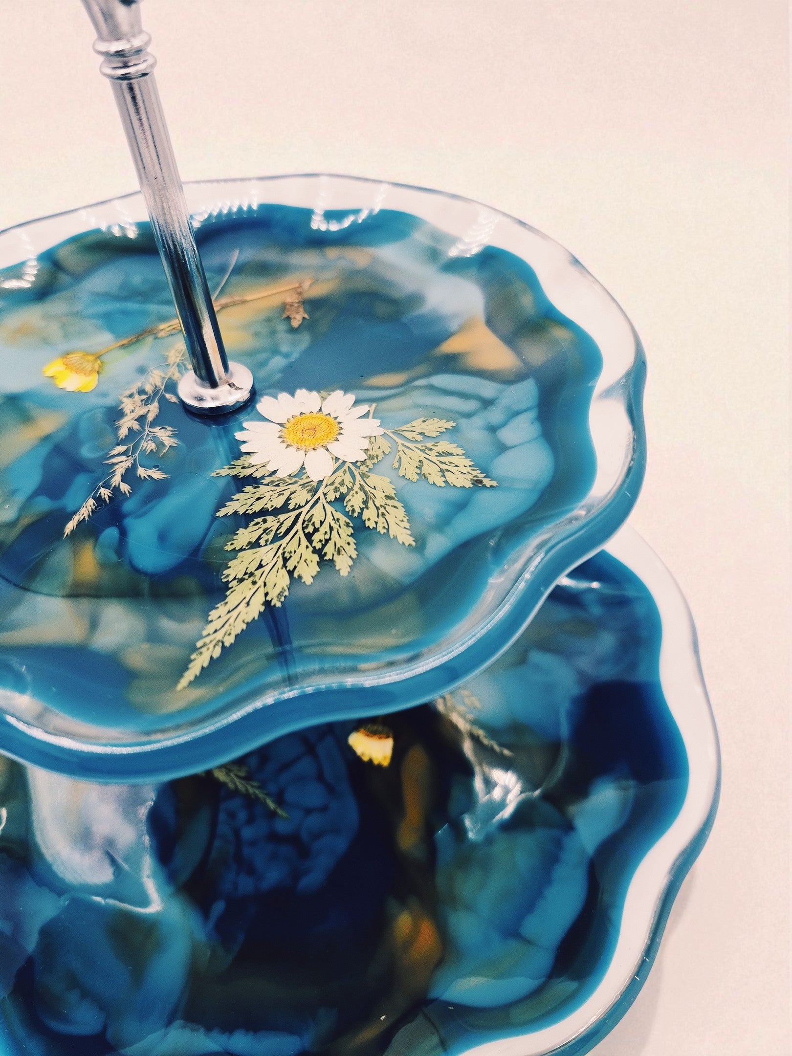 Nahaufnahme der Epoxidharz-Etagere in Blau-Gold mit eingegossener Blüte – Kollektion Golden Hour – Maliora Designs
