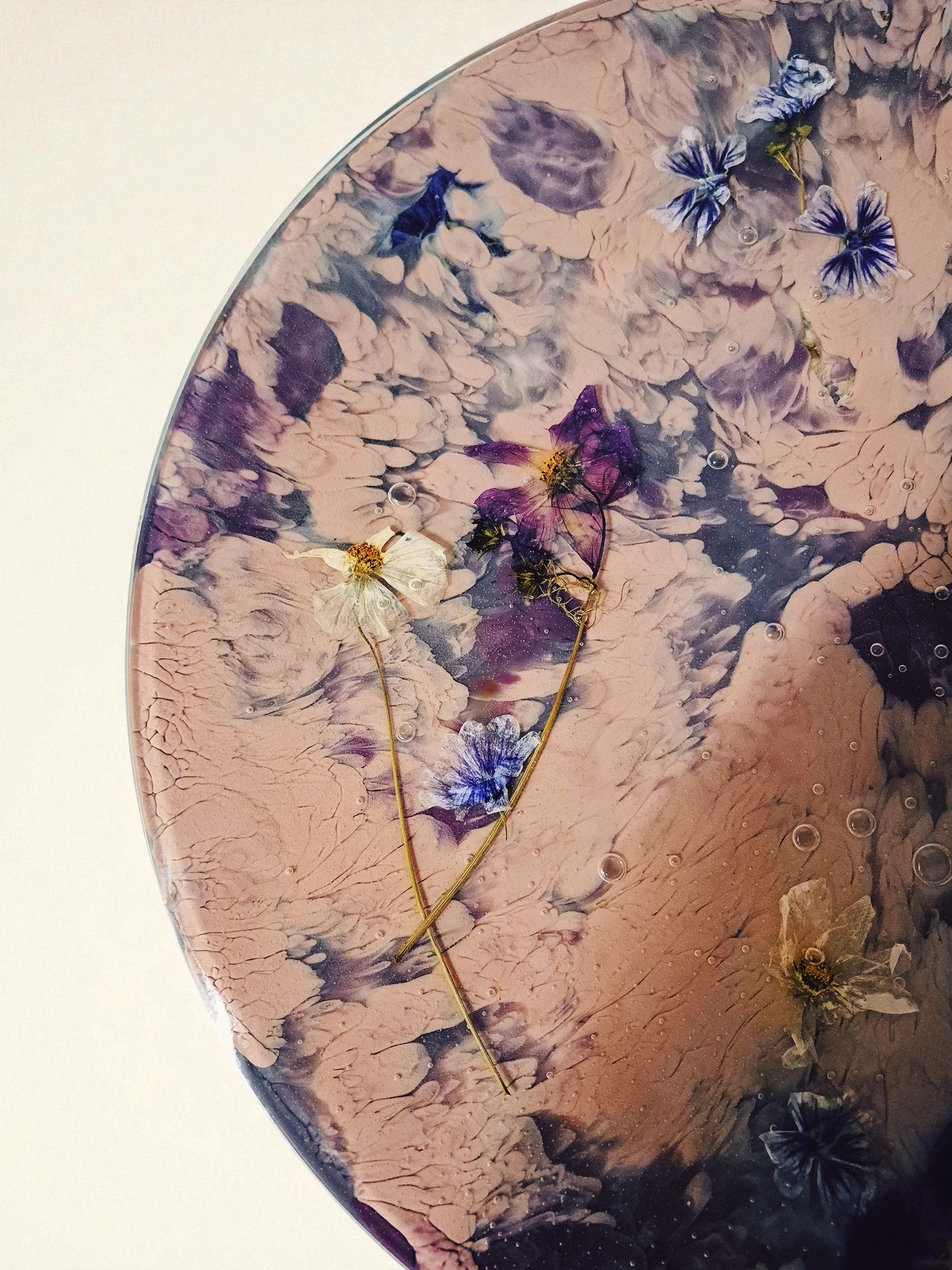 Nahaufnahme der Tischoberfläche von „Violet Veil“ mit zarten Blüten in Flieder, Blau und Weiß, eingebettet in glänzendes Harz mit marmorierter Struktur.