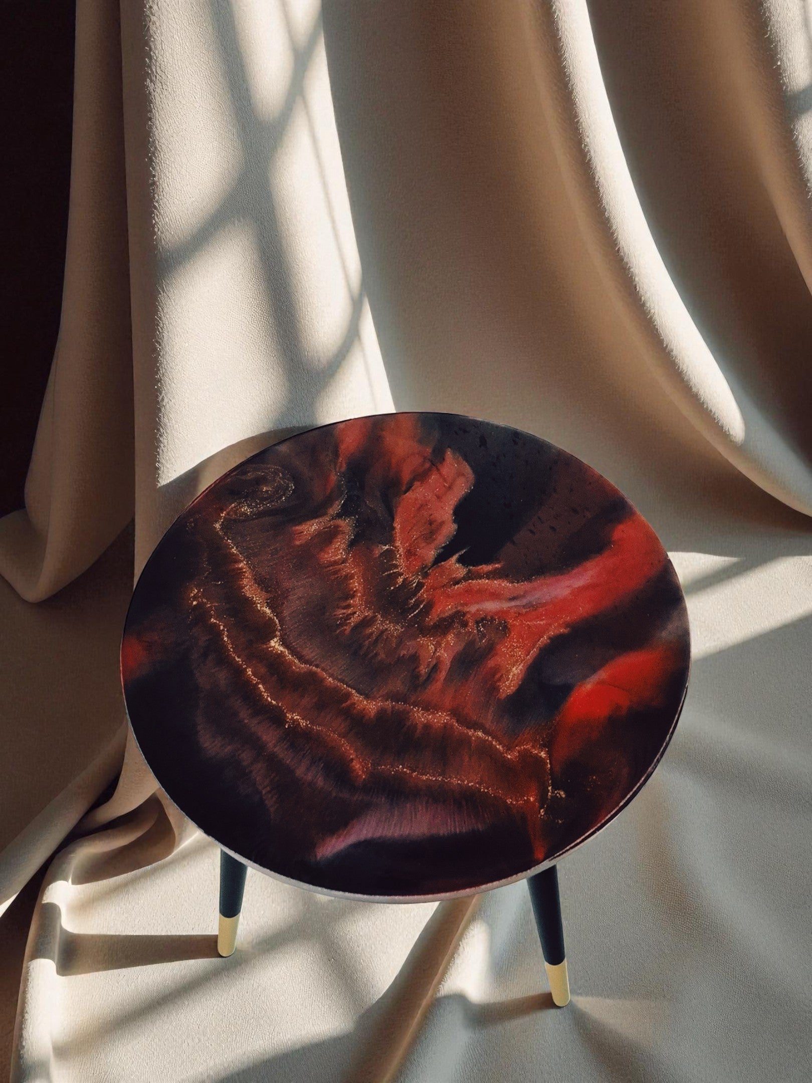 Beistelltisch ‚Falling Ember‘ von oben fotografiert, rot-schwarzer Epoxidharz-Tisch mit glühender Struktur und goldenen Linien auf beigem Hintergrund.