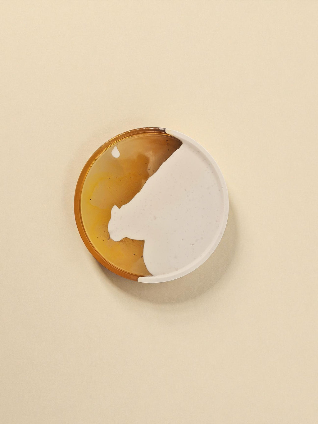 Rundes Tablett „Melted Sun“ aus Jesmonite und Epoxidharz, auf hellem Untergrund mit sanfter Schattenbildung fotografiert.