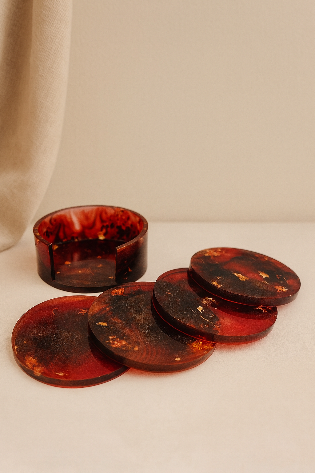 Set aus runden Epoxidharz-Untersetzern und Dose in Rotbraun mit Goldakzenten, vor neutralem Hintergrund – Maliora Designs